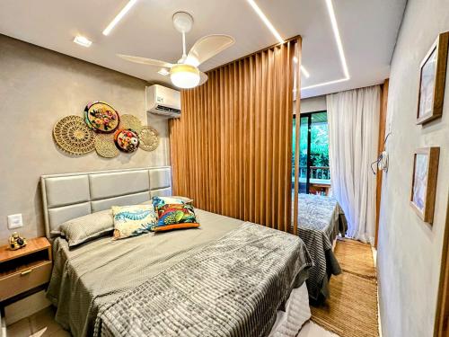 a bedroom with two beds and a ceiling fan at Muro Alto Marulhos flat cinematográfico in Porto De Galinhas