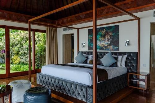 a bedroom with a large bed with a canopy at The Edge Bali in Uluwatu