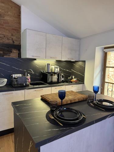 - une cuisine avec 2 verres à vin sur un comptoir dans l'établissement Aux Petits Oignons, à Albi