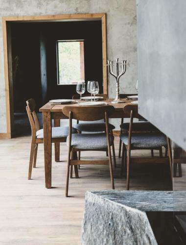 une salle à manger avec une table en bois et des verres à vin dans l'établissement Chalet Casteret-15 couchages-brasero-bain nordique, à Guchan