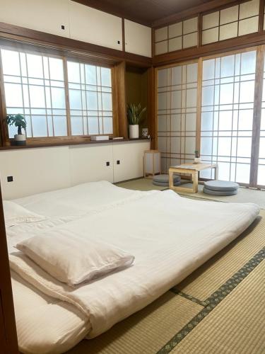 a large white bed in a room with windows at 全新装修南品川Haven有1间和室共2卧室 in Tokyo