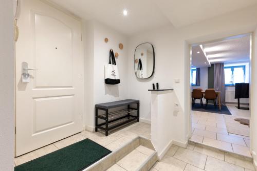 a hallway with a white door and a green rug at Traumwerk24 - Altstadt Suite Augsburg in Augsburg