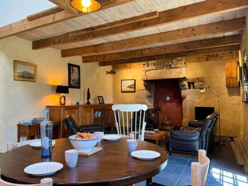 une salle à manger avec une table en bois et un salon dans l'établissement Rhun Even, charmante maison bretonne pour 6 personnes, à Plougasnou