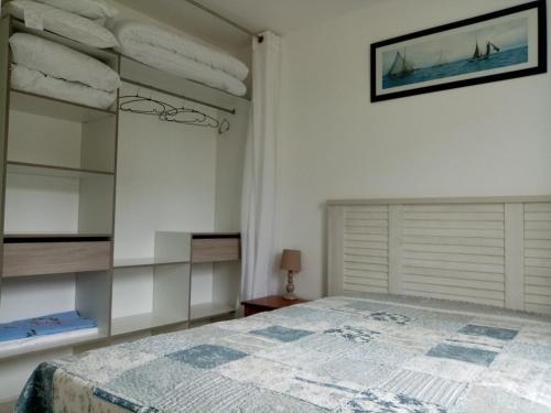 une chambre avec un lit et un miroir dans l'établissement Location maison à 400m de la plage, à Penvins