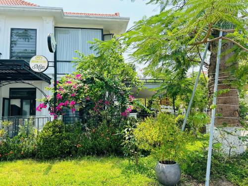 a garden in front of a house with flowers at MUN HomeSTAY 3 in Hue