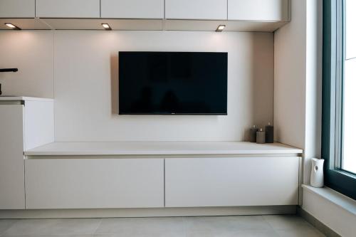 Una sala de estar con un televisor en una pared blanca. en New Modern Apt Near City and Gare Lux, en Luxemburgo