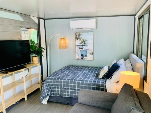 a small room with a bed and a tv at Mornington Peninsula Retro Caravans in Rye