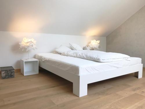 a white bed with white sheets and pillows at denkmal19 - pirrung lebensräume in Sankt Ingbert