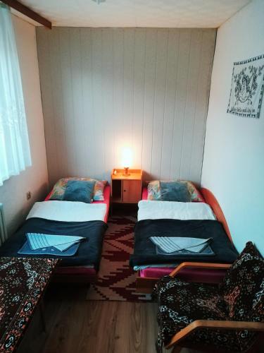 a room with two beds and a table with a lamp at Privat Ludmila in Liptovská Teplička