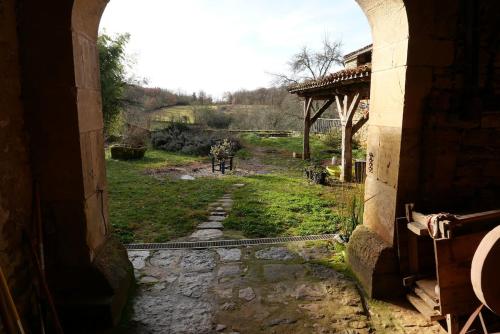 un accès à un bâtiment avec vue sur un champ dans l'établissement La Contie, bol d'air et de nature, à Najac