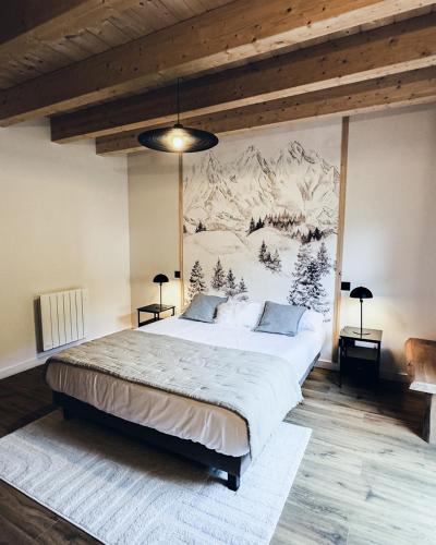 une chambre avec un grand lit avec un tableau au mur dans l'établissement Chalet Casteret-15 couchages-brasero-bain nordique, à Guchan