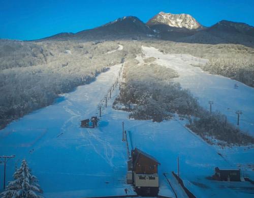 a ski slope with a ski lift in the snow at Lodge Myoko in Akakura