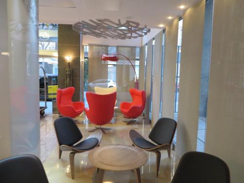 a group of chairs and a table in a room at Evenia Rossello in Barcelona