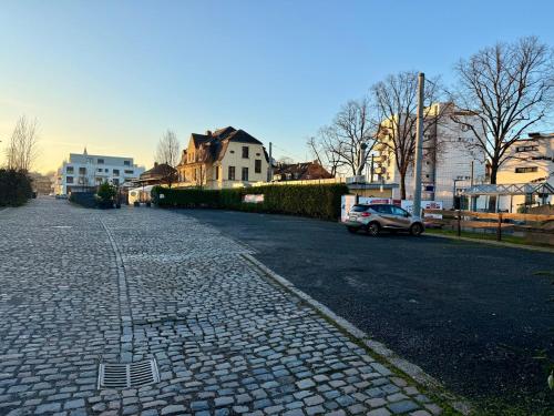 a cobblestone street with houses and a car on it at Rhein Haven Appartment für bis zu 12 Gäste im historischen Bahnhofsgebäude in Frechen
