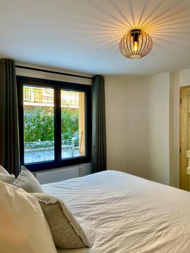 une chambre avec un lit blanc et une fenêtre dans l'établissement Rêve du Criou, à Samoëns