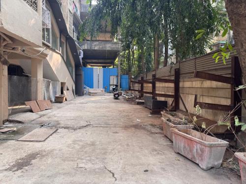 an empty alley with a building and a blue fence at Hotel West Line Andheri in Mumbai