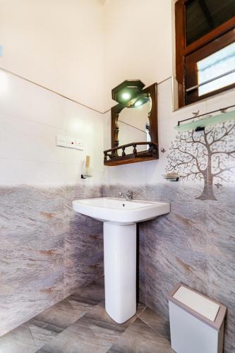 a bathroom with a white sink and a mirror at We Are Surfers Hotel in Weligama