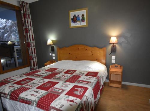 - une chambre avec un lit doté d'une couette rouge et blanche dans l'établissement VAUJANYLOCATIONS - Crystal407, à Vaujany