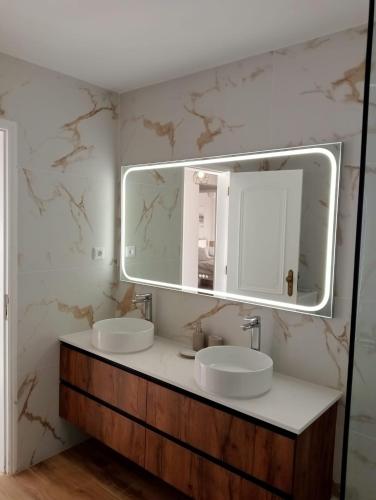 a bathroom with two sinks and a large mirror at Ericeira Mar à vista - Seaview apartment in Ericeira
