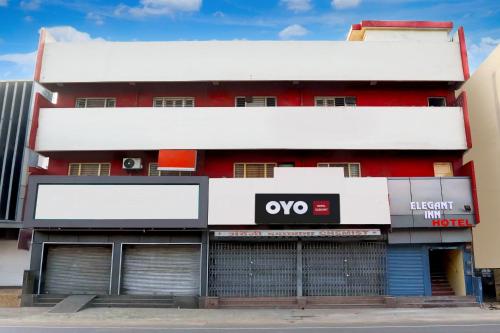 un edificio rojo con una señal blanca delante de él en HOTEL O ELEGANT, en Prayagraj