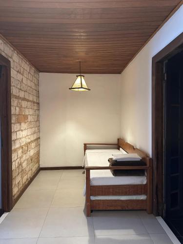 a room with a bed and a table with a light at Pousada Estrelas no Mar Florianópolis in Florianópolis