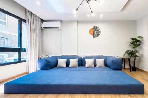 a large blue couch in a living room with a window at The 2BDR Obsidian Jacuzzi Stay 5min to CAI Airport in Cairo