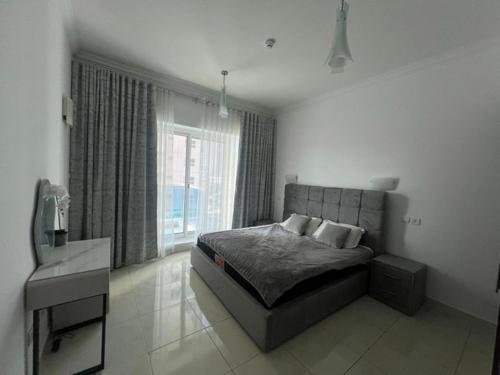 een slaapkamer met een bed en een groot raam bij Opal Tower in Dubai
