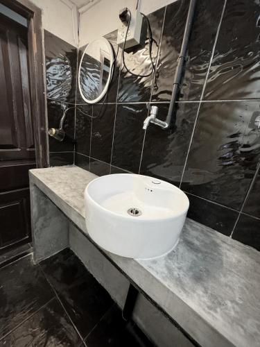a bathroom with a white sink and two mirrors at Truman Hostel in Luang Prabang