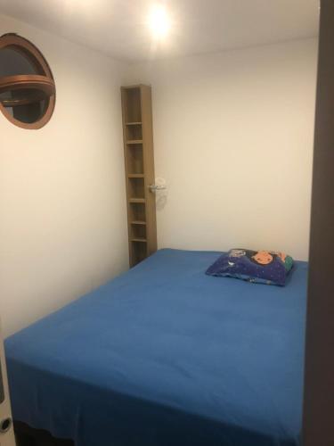 - une chambre avec un lit bleu et une étagère dans l'établissement Résidence Athéna Port, à Bandol