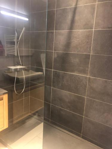 La salle de bains est pourvue d'une douche et d'un mur en carrelage. dans l'établissement Résidence Athéna Port, à Bandol