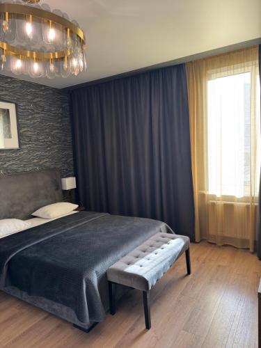 a bedroom with a large bed and a chandelier at Apartments Lux in city center Lviv in Lviv