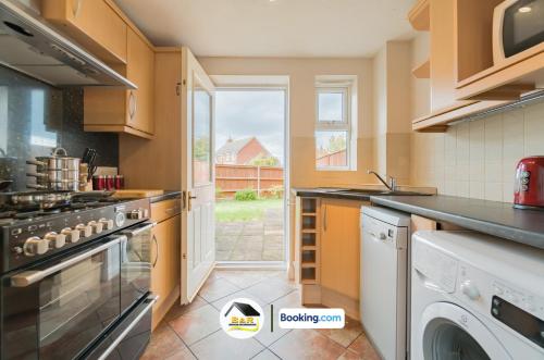 a kitchen with a stove and a window at 3 Bed Detached House By B and R Serviced Accommodation Amesbury With Free Parking & Garden in Amesbury