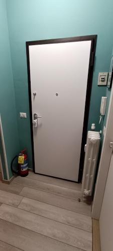 a white door in a bathroom with a wooden floor at L'Alloggetto sul Corso in Cuneo