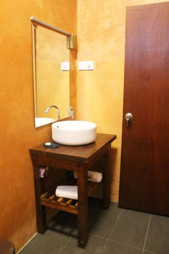 a bathroom with a white sink and a mirror at Coral Seas Beach Hikkaduwa in Hikkaduwa