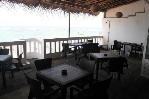 a restaurant with tables and chairs and a view of the ocean at Coral Seas Beach Hikkaduwa in Hikkaduwa