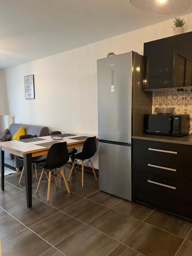 une cuisine avec une table et un réfrigérateur dans l'établissement Appartement moderne et lumineux, à Strasbourg