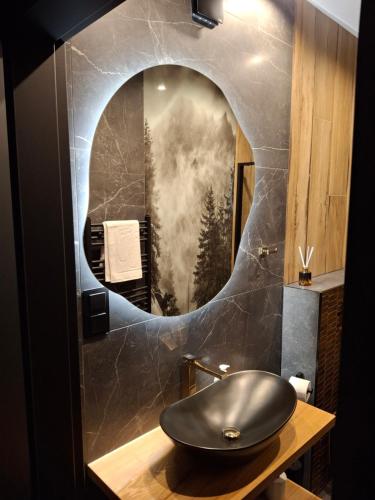 a bathroom with a black sink and a mirror at Zwierzyniecka Residence in Zakopane
