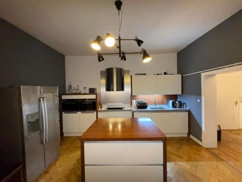 a kitchen with white cabinets and a wooden table in it at Geräumige 4-Zimmer-Wohnung im familienfreundlichen Westend mit Balkon in Frankfurt/Main