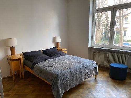 a bedroom with a bed and a large window at Geräumige 4-Zimmer-Wohnung im familienfreundlichen Westend mit Balkon in Frankfurt/Main