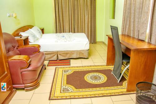 a bedroom with a bed and a desk and a television at RESIDENCE HOTEL Moungali in Brazzaville