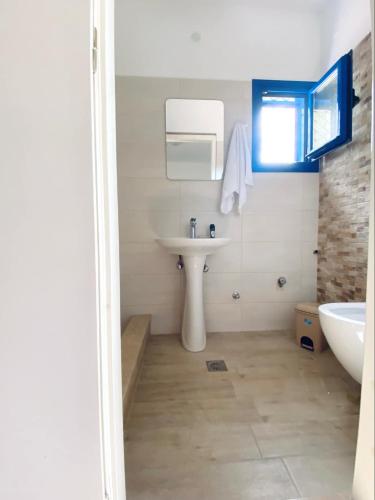 a white bathroom with a sink and a tub at Emborios Views - Studio in Emborios