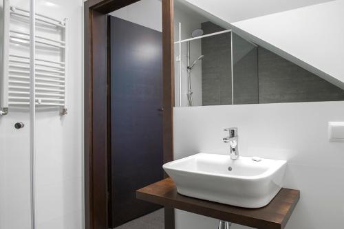 a bathroom with a white sink and a staircase at Zajazd Ryszkówka in Bestwina