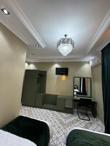a bedroom with two beds and a desk and a chandelier at Light Hotel in Samarkand