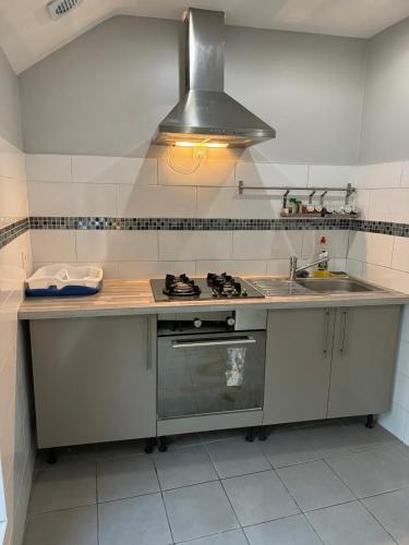une cuisine avec un évier et une cuisinière four supérieur dans l'établissement Quiet self-catering apartment, à Aubervilliers