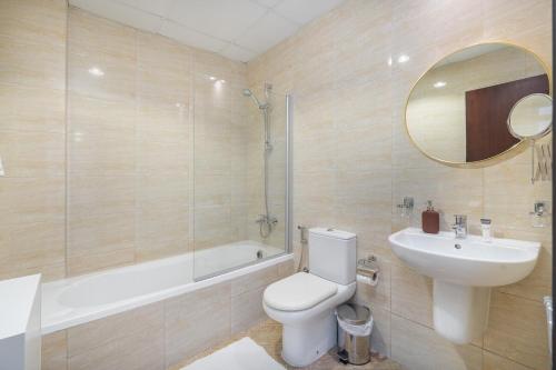 a bathroom with a toilet and a sink and a mirror at Free housekeeping visits during your stay - StayShort - Comfy 1-Bedroom Apartment Perfect for 4 in JLT in Dubai