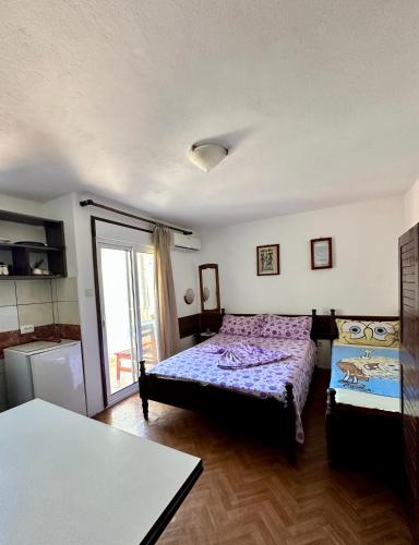 a bedroom with a bed and a kitchen with a window at Heaven Apartments in Ulcinj