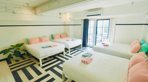 a room with two beds and a couch at The Locals Bangkok Old Town in Bangkok