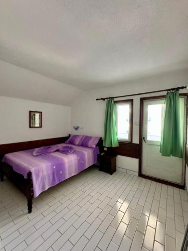 a bedroom with a purple bed and green curtains at Heaven Apartments in Ulcinj