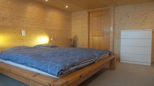 a bedroom with a bed in a wooden wall at Mällis Heimetli in Urnäsch