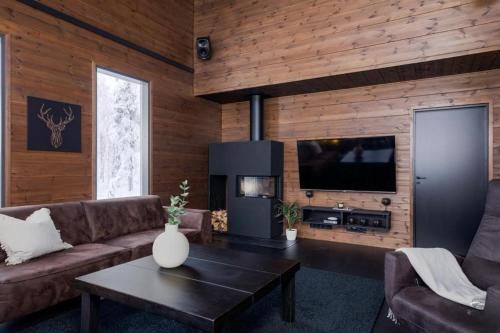 een woonkamer met een bank en een salontafel bij Villa Aspen D Ski-in Ski-out by Aavalevi in Levi